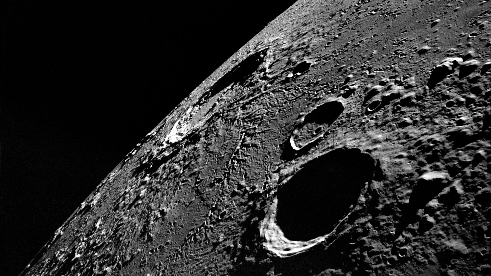 An Apollo 12 high-oblique view of the lunar nearside looking northeast toward the crater Copernicus (in center near horizon), as photographed from lunar orbit.
