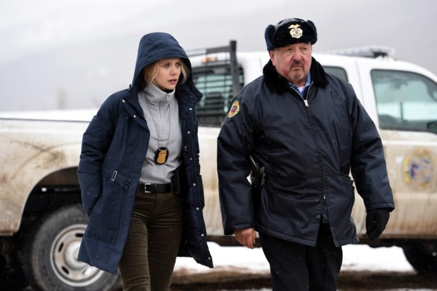 A female cop and a male cop walk next to each other.