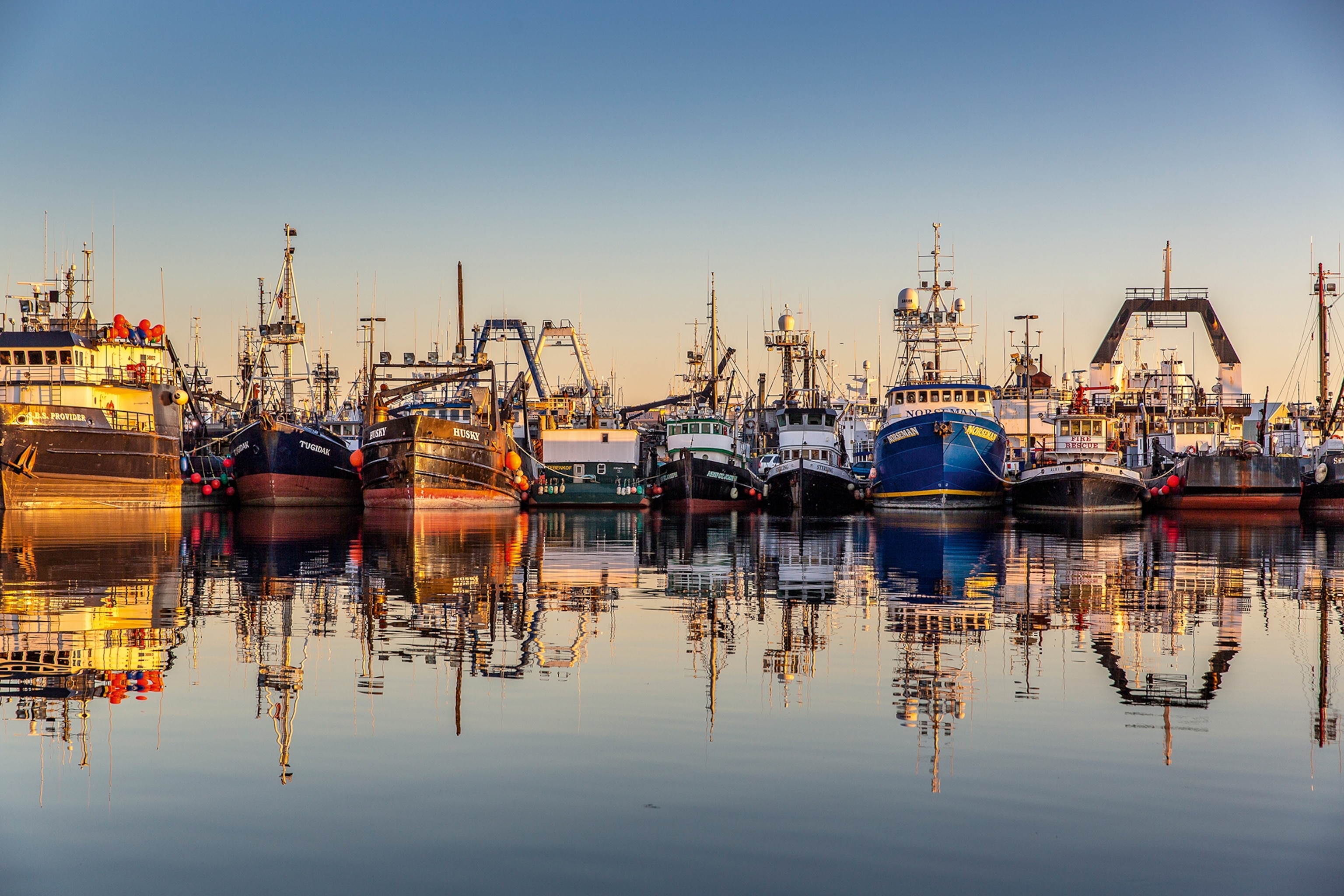 A view on the Seattle port at sunset with crab boast lined up on the dock.
