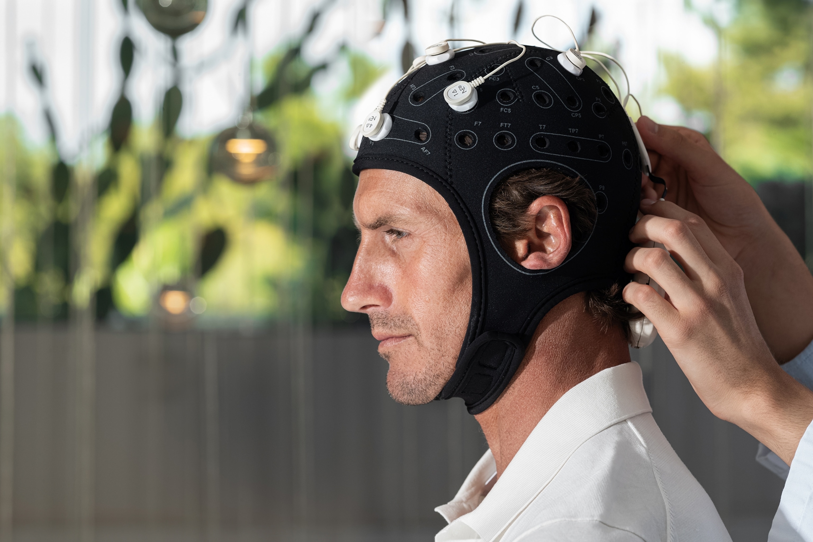 A man wearing a cap with electrodes attached.