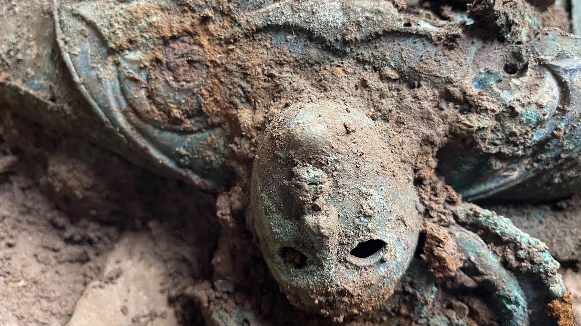 Close up of mask-like face decoration on Iron Age vessel