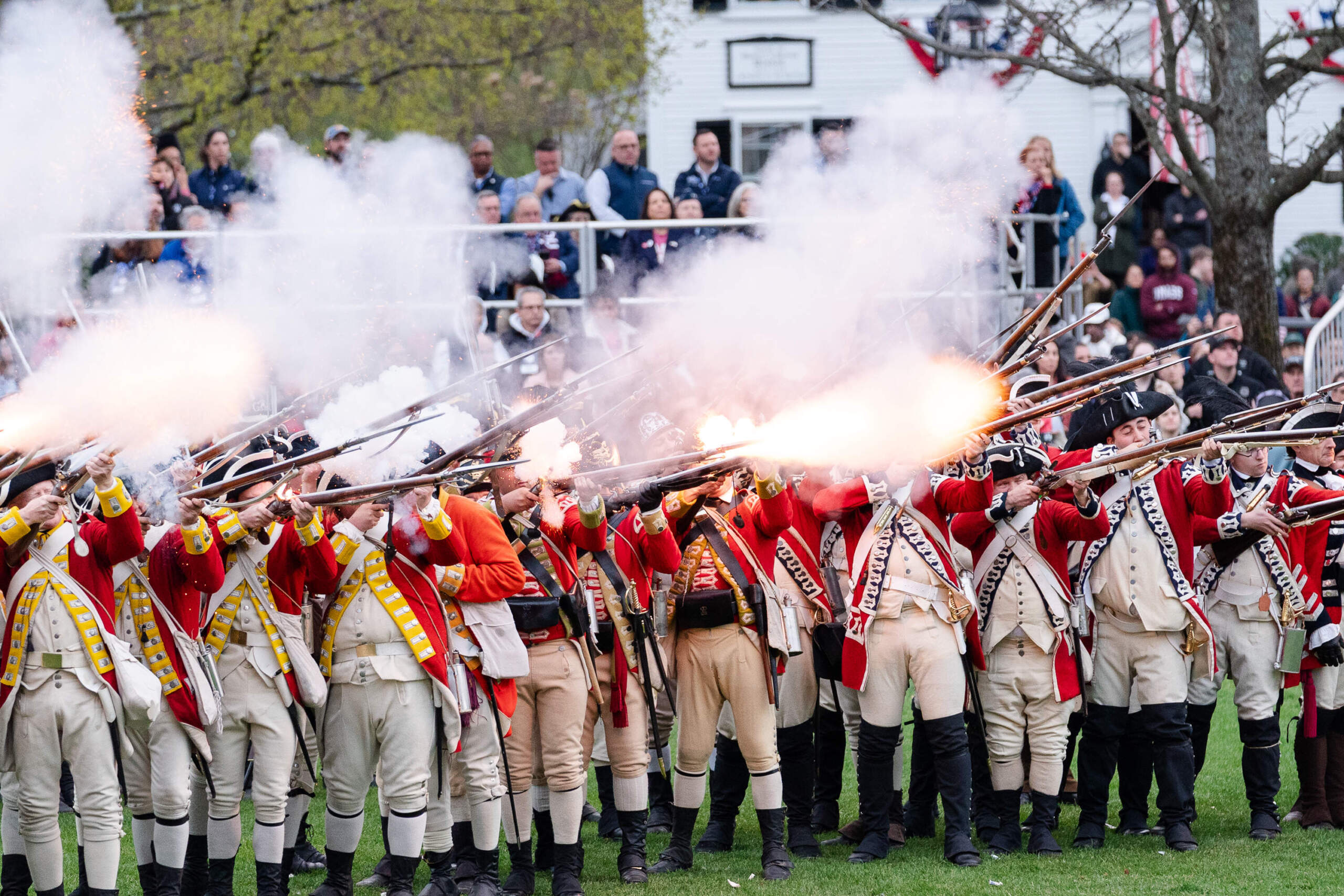 Reenactors depicting British regulars fire their weapons. (Sophie Park/Getty Images)
