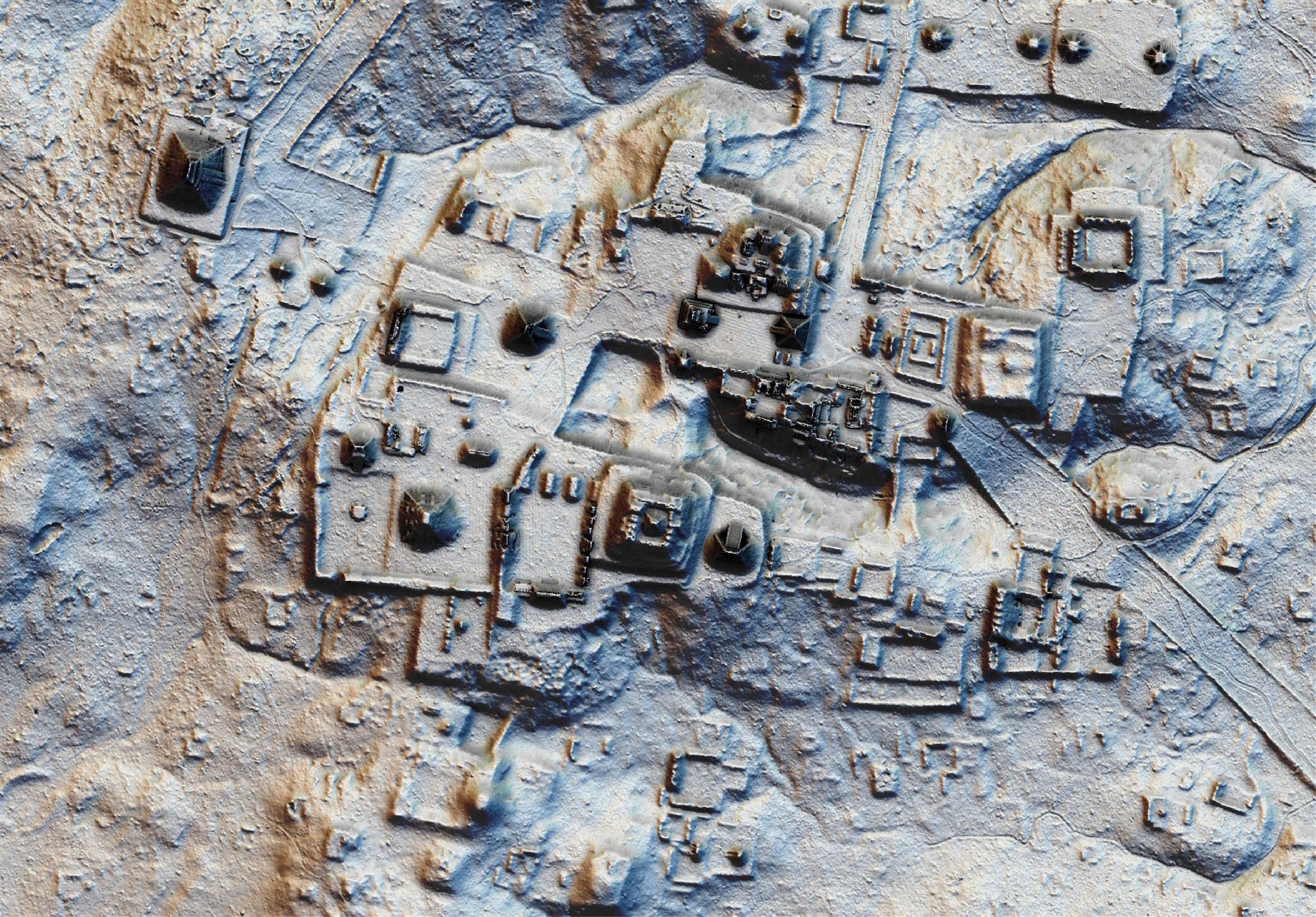 An aerial view of a landscape of varied shades of yellow, gold, and black showing shapes, objects, and shadows in 3D.