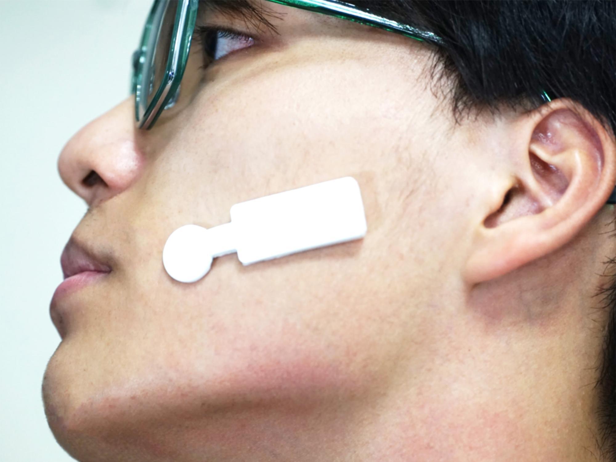 a band-aid-size device on a man's face