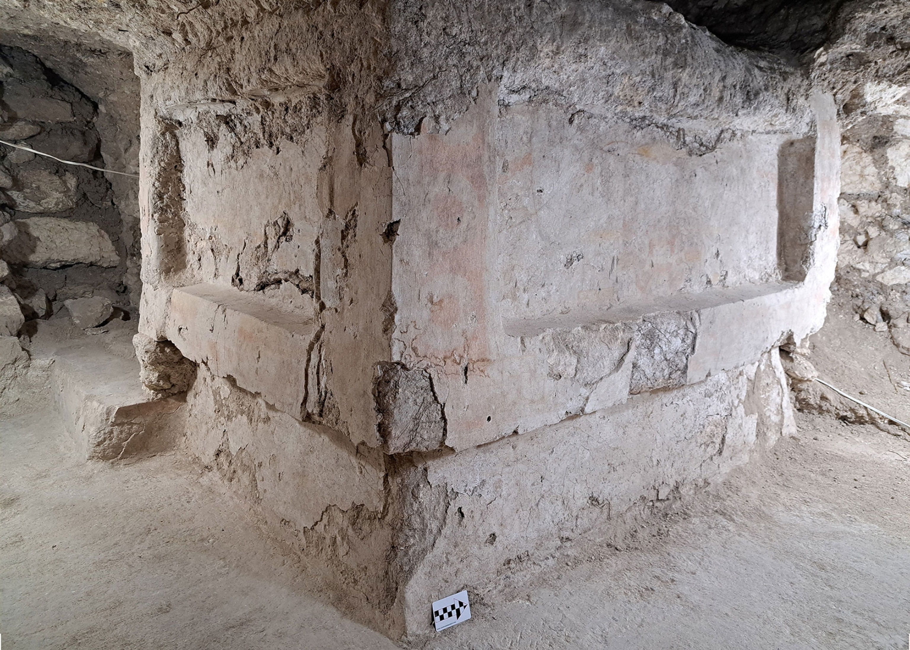 a buried mayan altar made a light, sandy colored stone, underground.