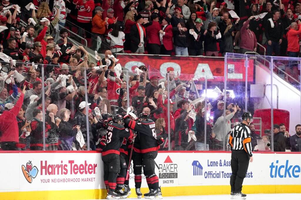 RALEIGH, NORTH CAROLINA - MAY 12: Shayne Gostisbehere #4 of the Carolina Hurricanes celebrates with teammates after scoring a goal against the Washington Capitals during the first period of Game Four of the Second Round in the 2025 Stanley Cup Playoffs at at Lenovo Center on May 12, 2025 in Raleigh, North Carolina.  (Photo by Grant Halverson/Getty Images)