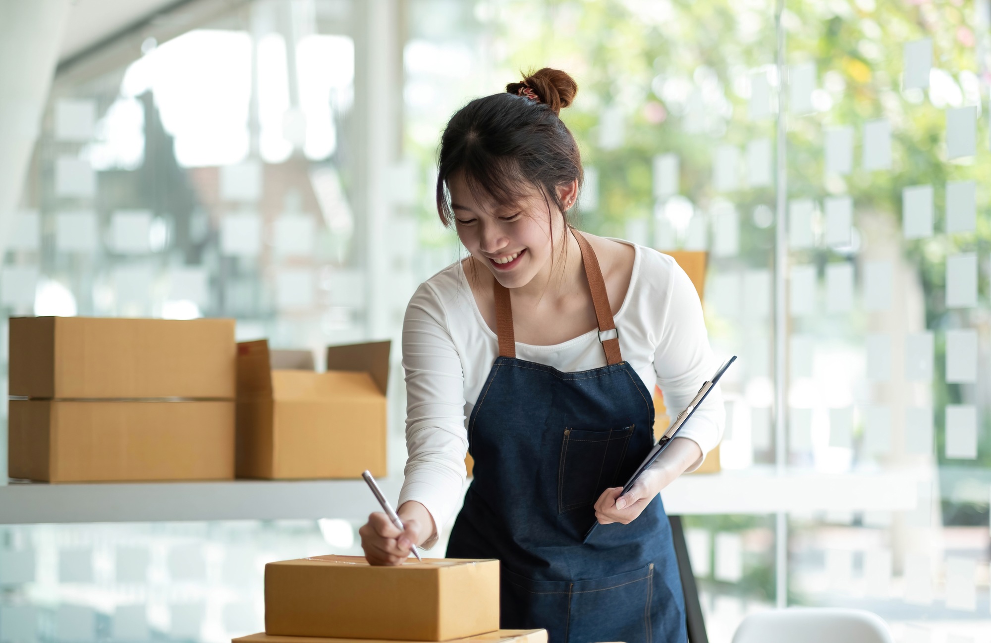 Startup happy Asian woman business owner works with a box at home, prepare parcel delivery SME