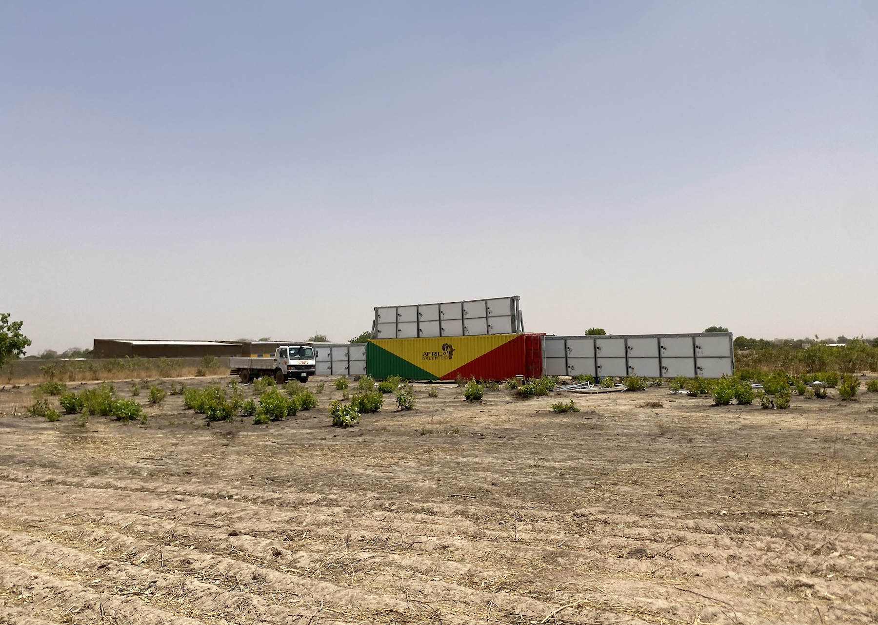 a shipping container surrounded by solar panels in desolate area