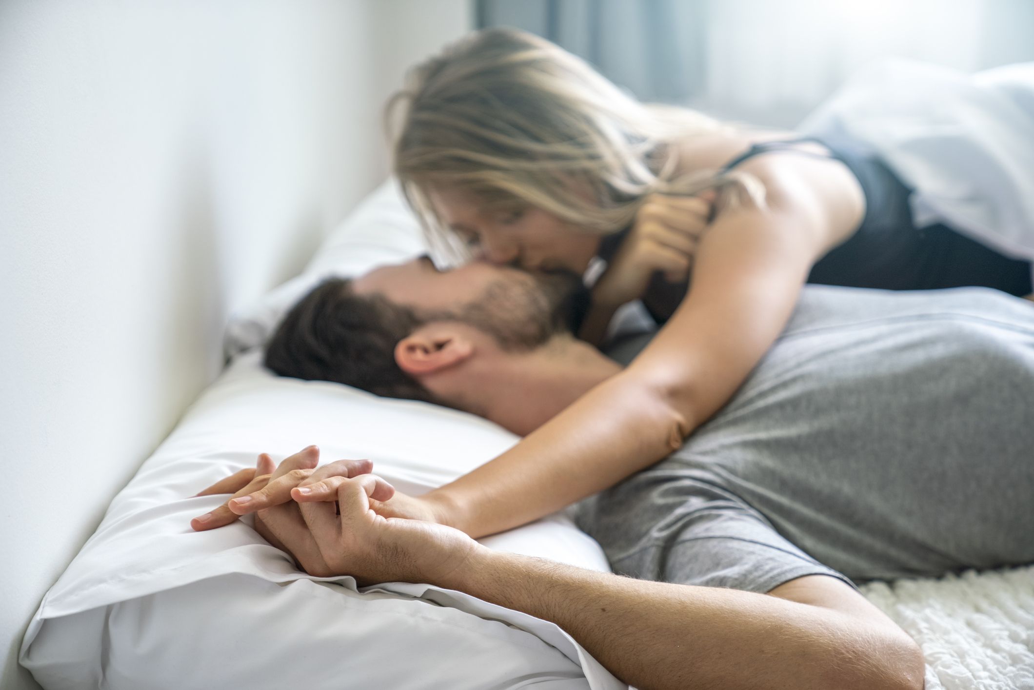 the young couple kissing in the bed