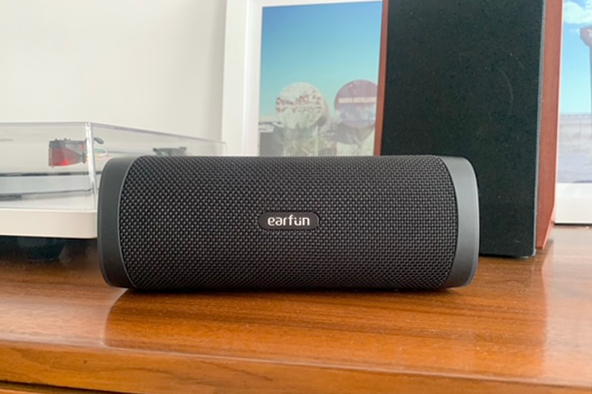 EarFun UBOOM L Bluetooth speaker in front of a turntable