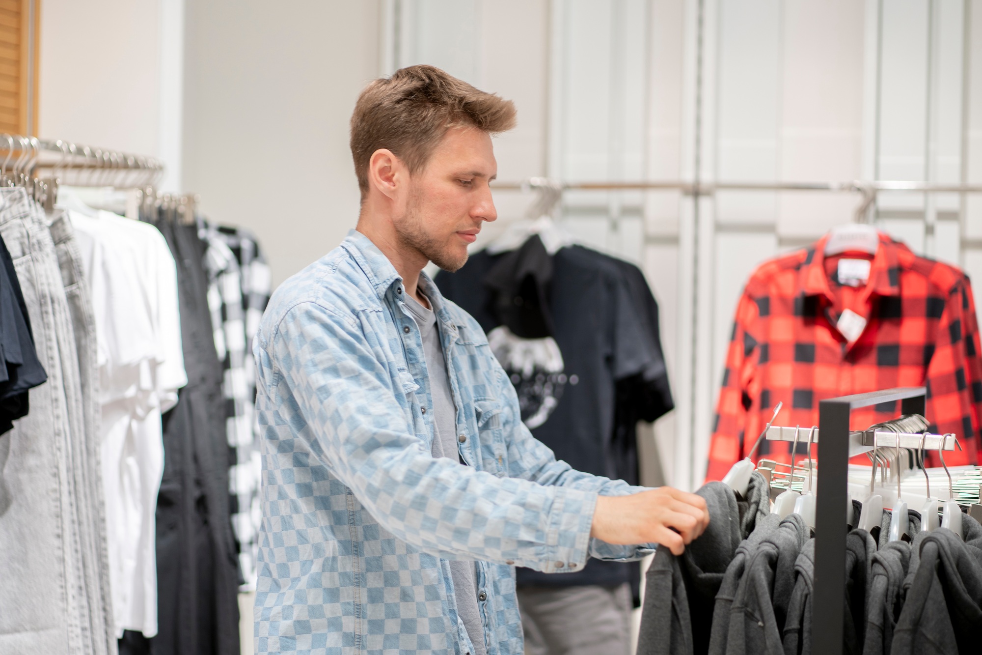 a man in the clothes retail shop, choosing the wear to buy