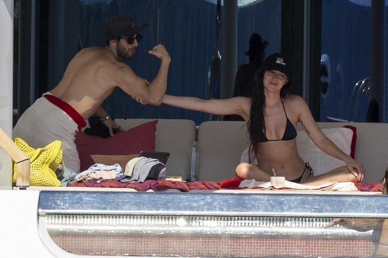 Dakota Johnson feeling a friend's bicep on a yacht in Ibiza, Spain