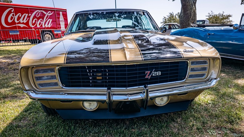 Front view of a black and gold 1969 Camaro Z/28 parked on grass