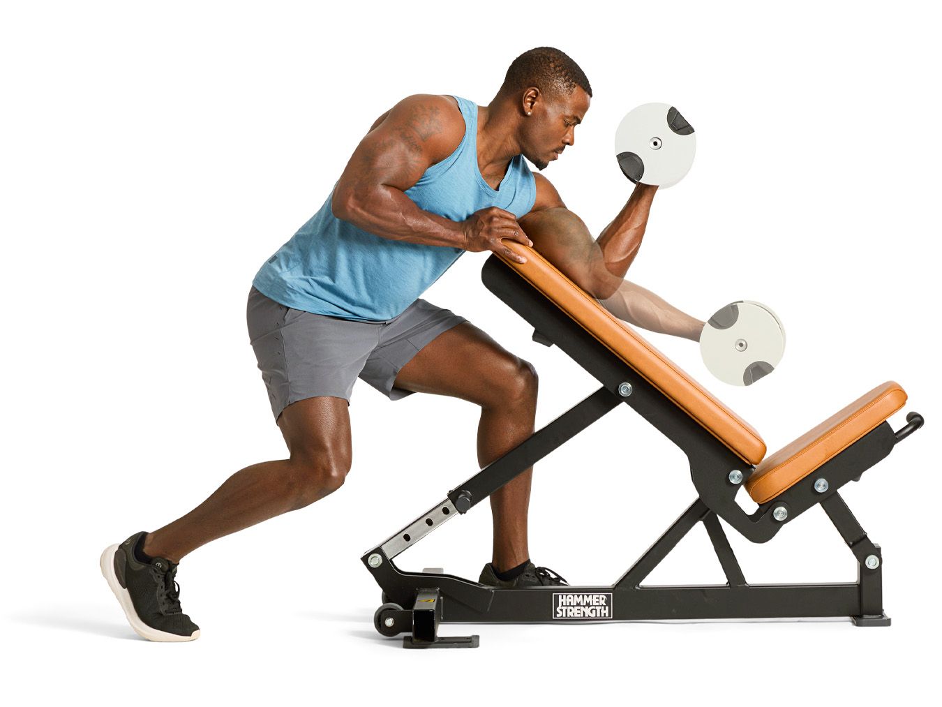 A male athlete performing a seated dumbbell exercise A male athlete performing a seated dumbbell exercise