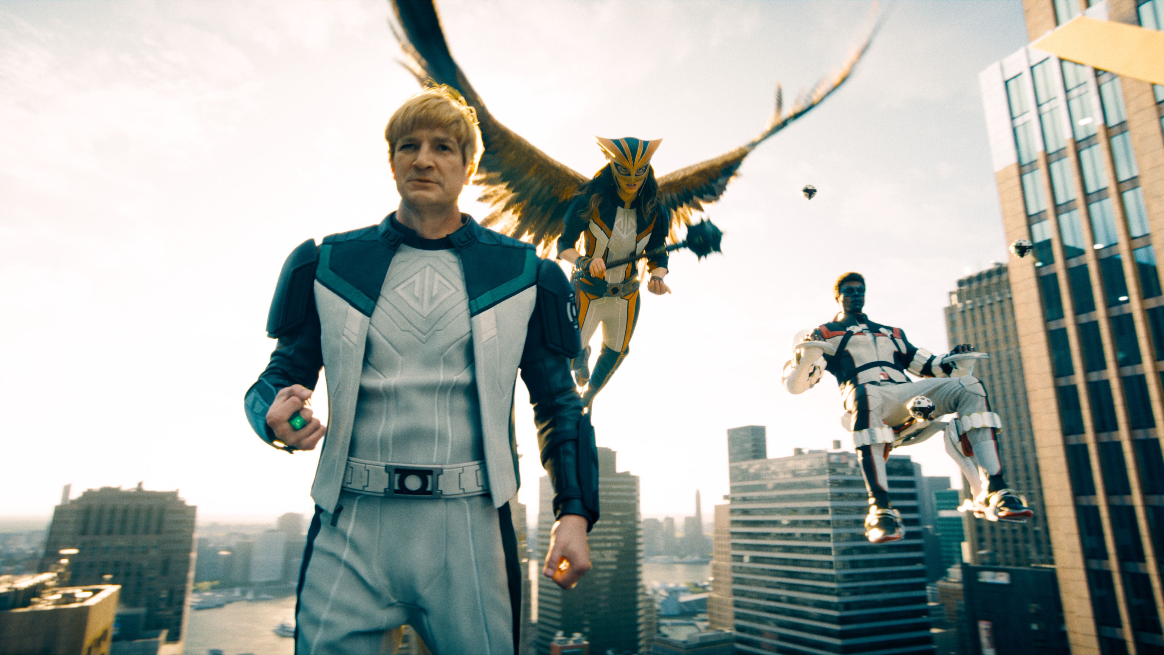 superheroes in futuristic outfits flying above a cityscape