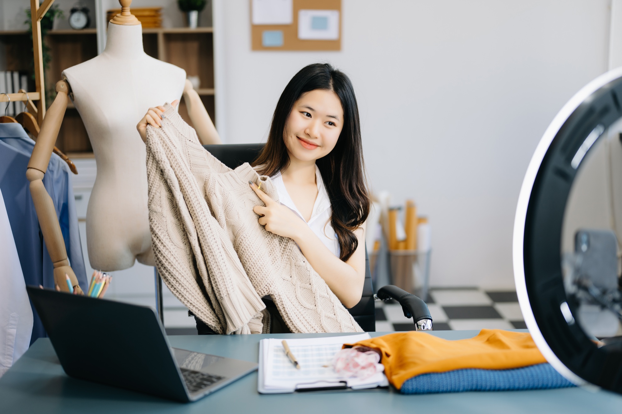 Asian lady blogger showing clothes in front of the camera to recording vlog video live streaming