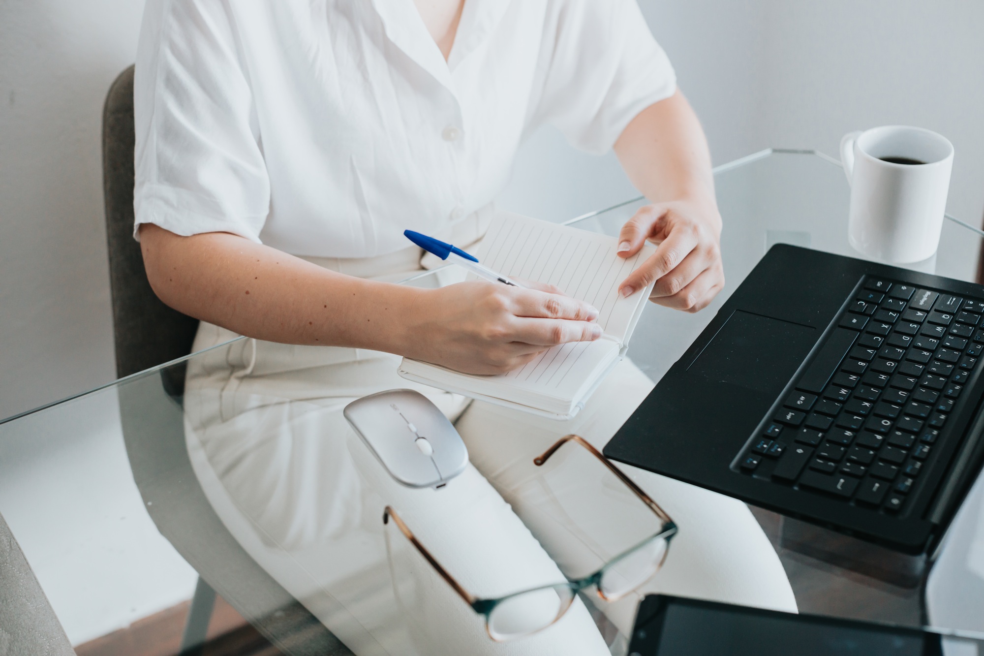 Close up image of a woman working at home office remotely,taking and writing notes and appointments,