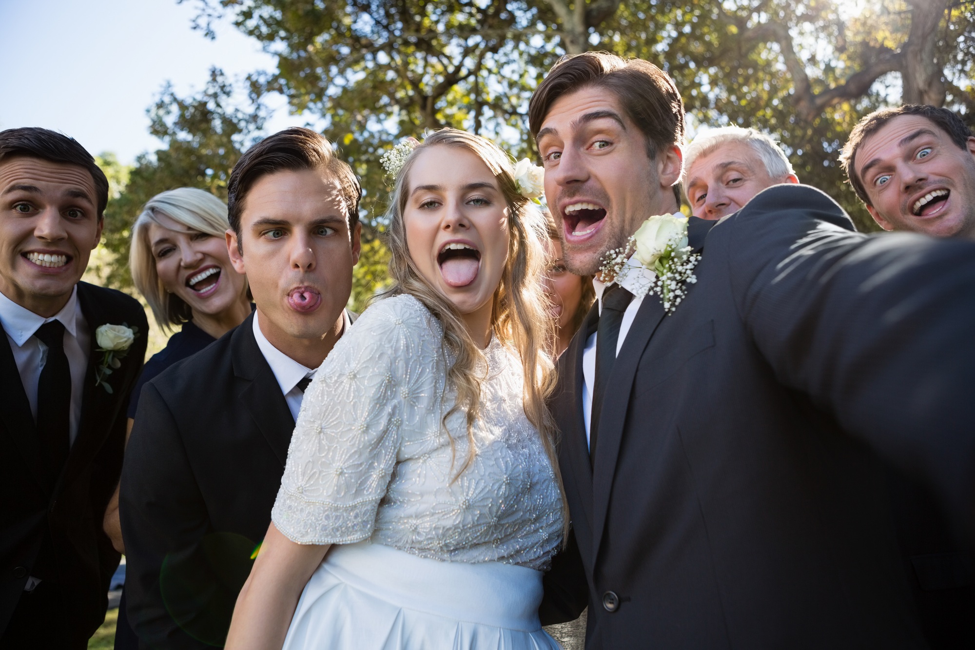 Happy couple posing with guests during wedding