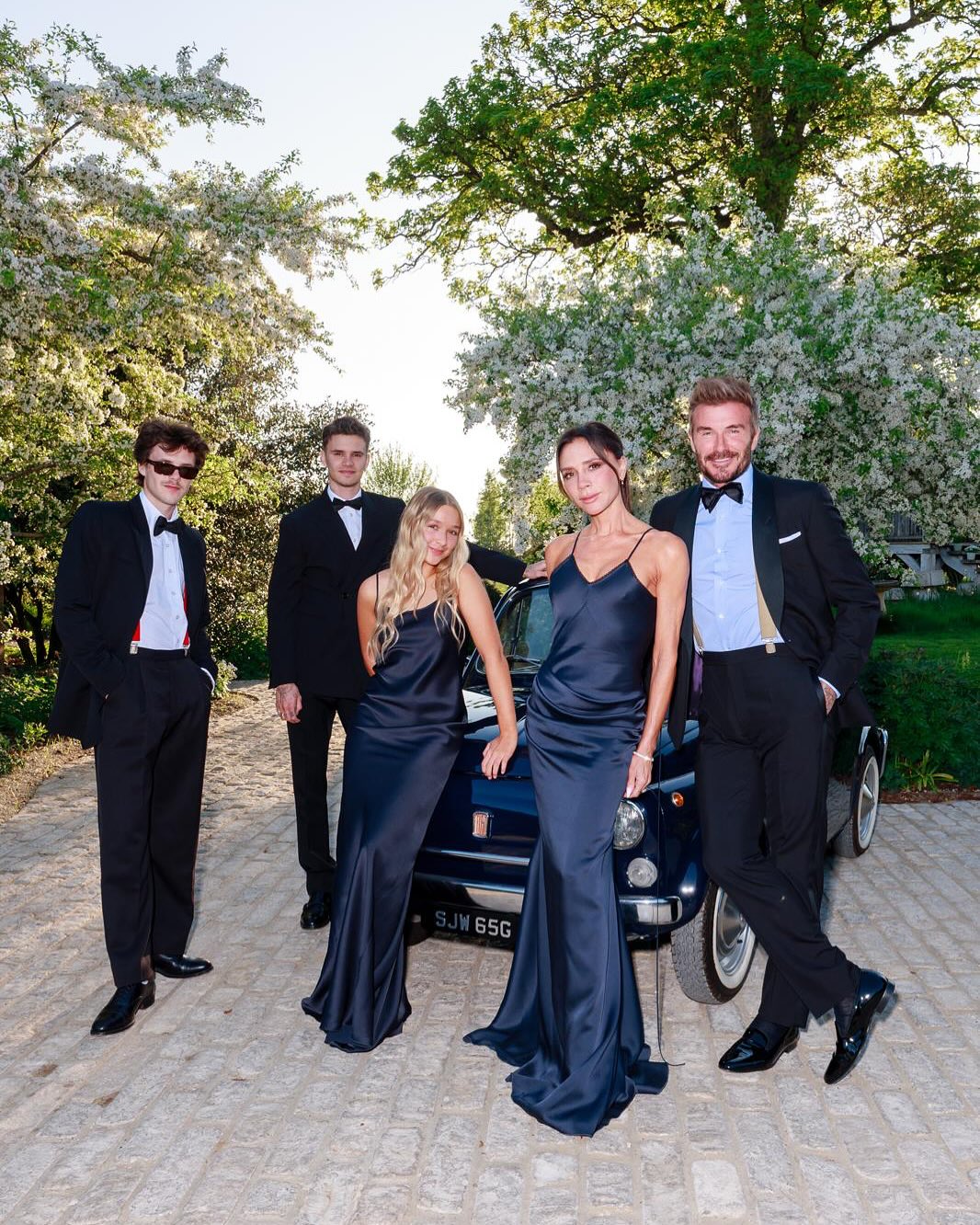 From left, Cruz Beckham, Romeo Beckham and David Beckham in tuxedos, Victoria Beckham and Harper Beckham in blue gowns.