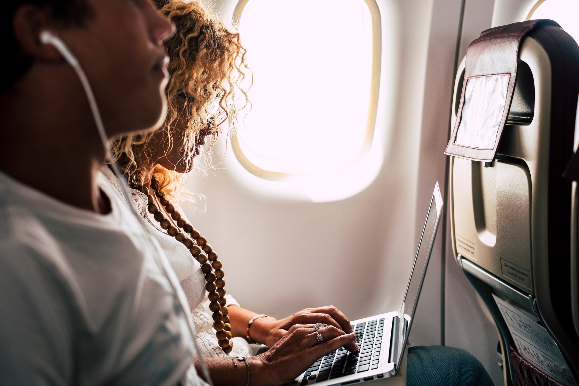 People couple use laptop computer on board in airplane flight with internet wireless connection