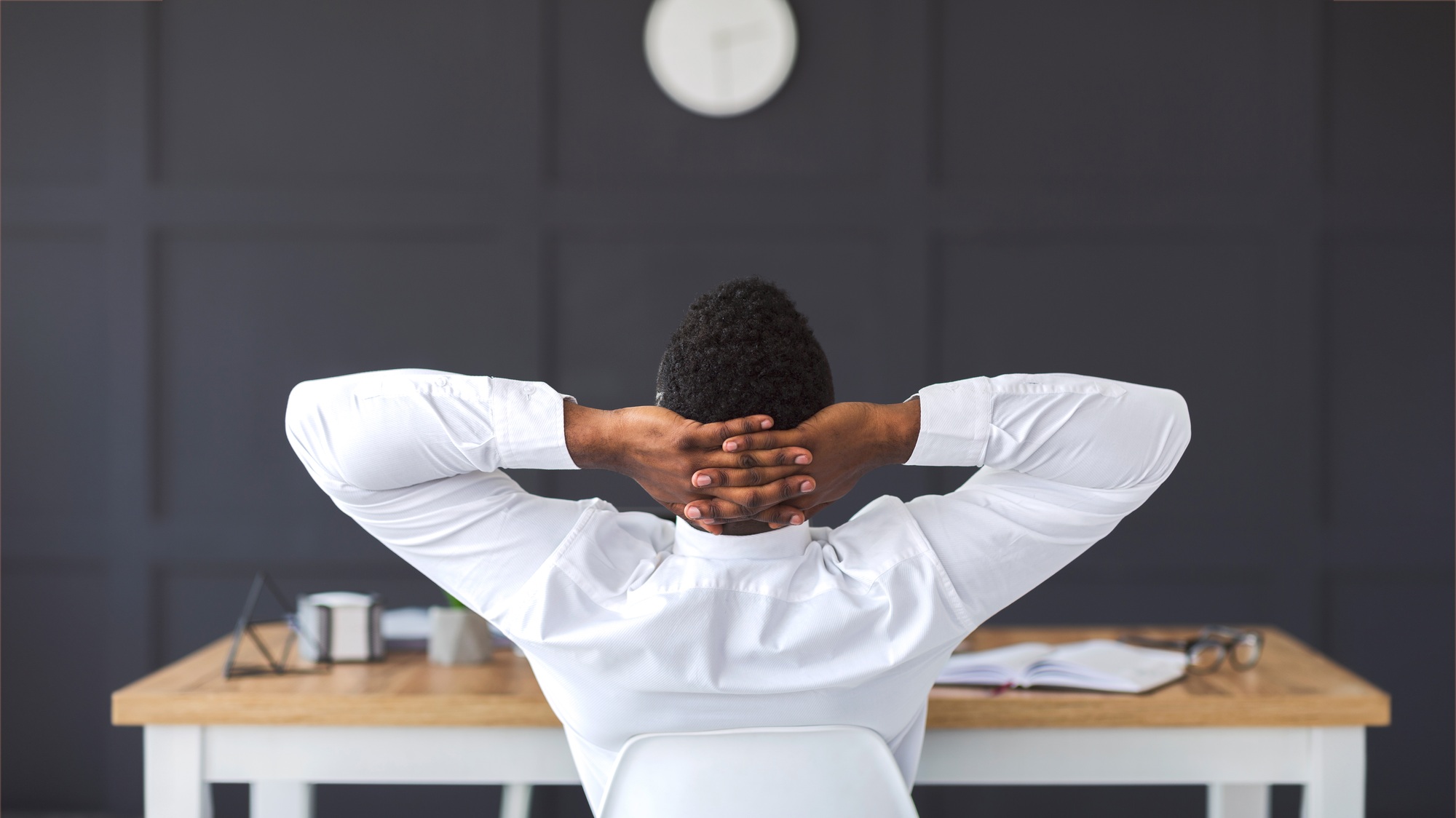 Rear view of african employee relaxing in office