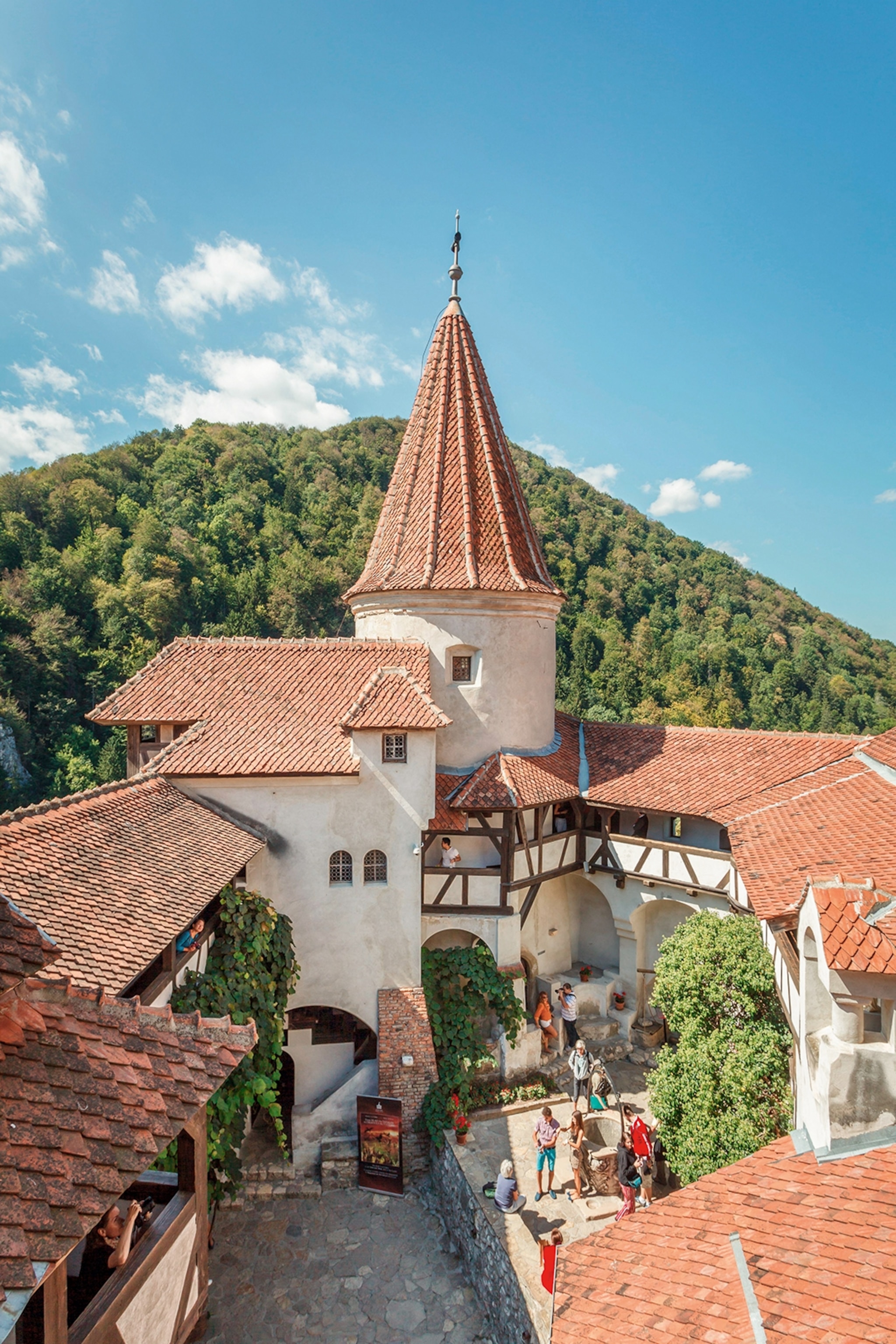 An aerial shot of a medieval castle courtyard with visitor and exposed beams in the façade.