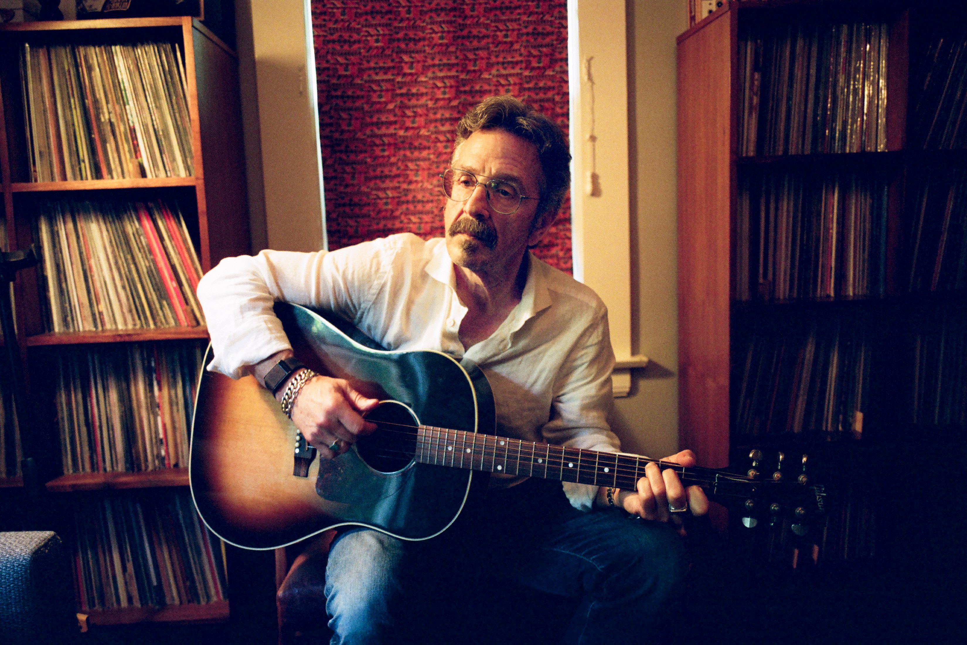 marc maron playing guitar in a room filled with vinyl records marc maron playing guitar in a room filled with vinyl records