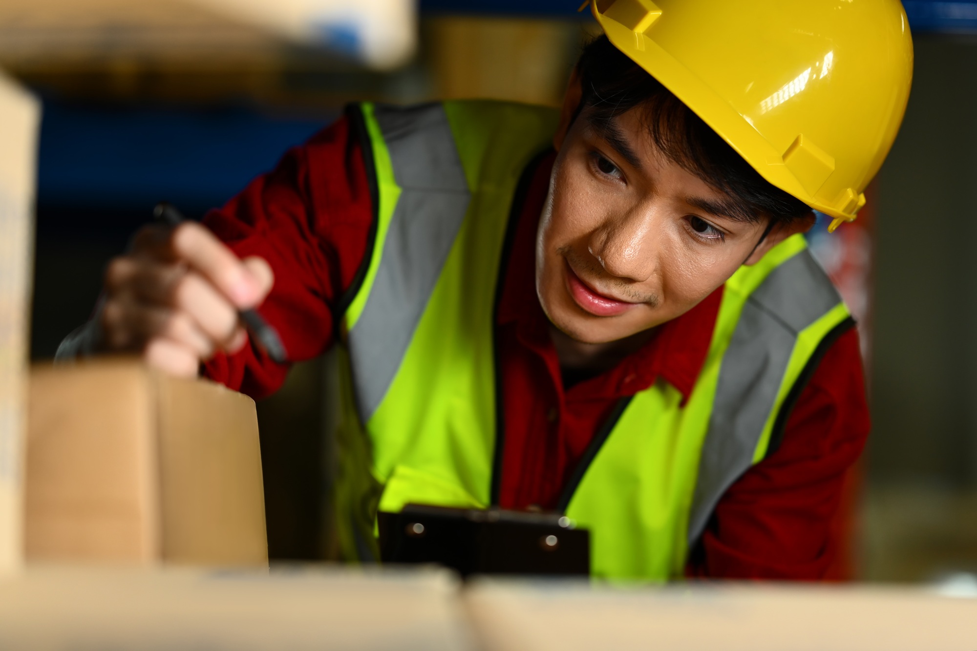 Storehouse worker checking stock and inventory on clipboard.