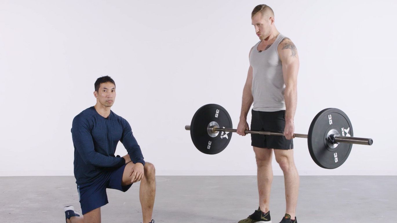 bodybuilder prepares heavy barbell for deadlift training