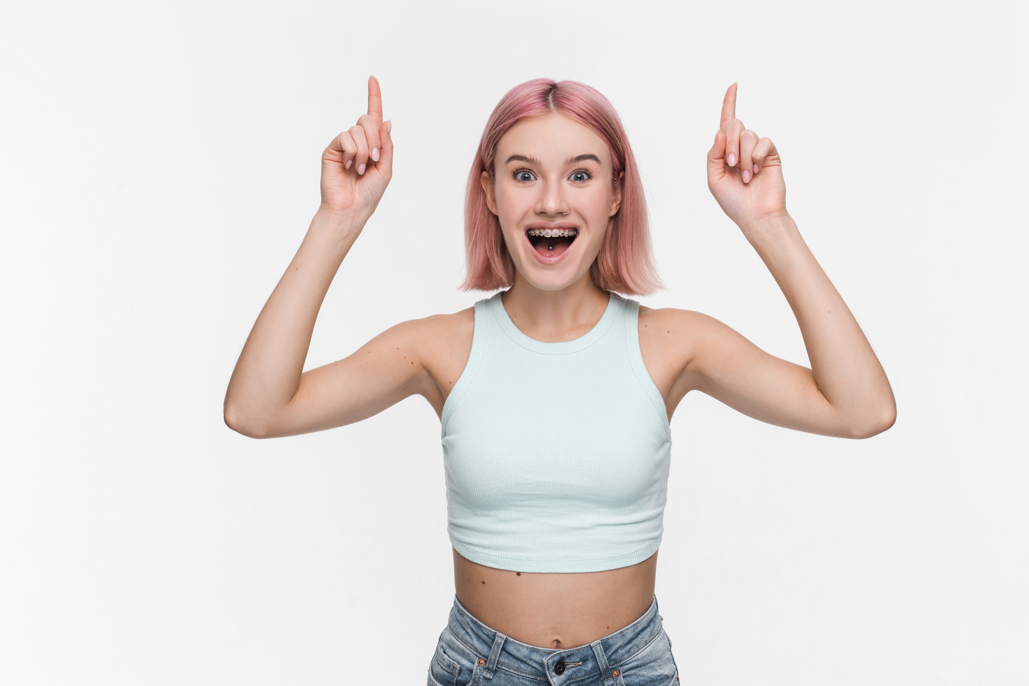 Amazed girl pointing fingers at logo sale promo showing advertisement isolated on white background
