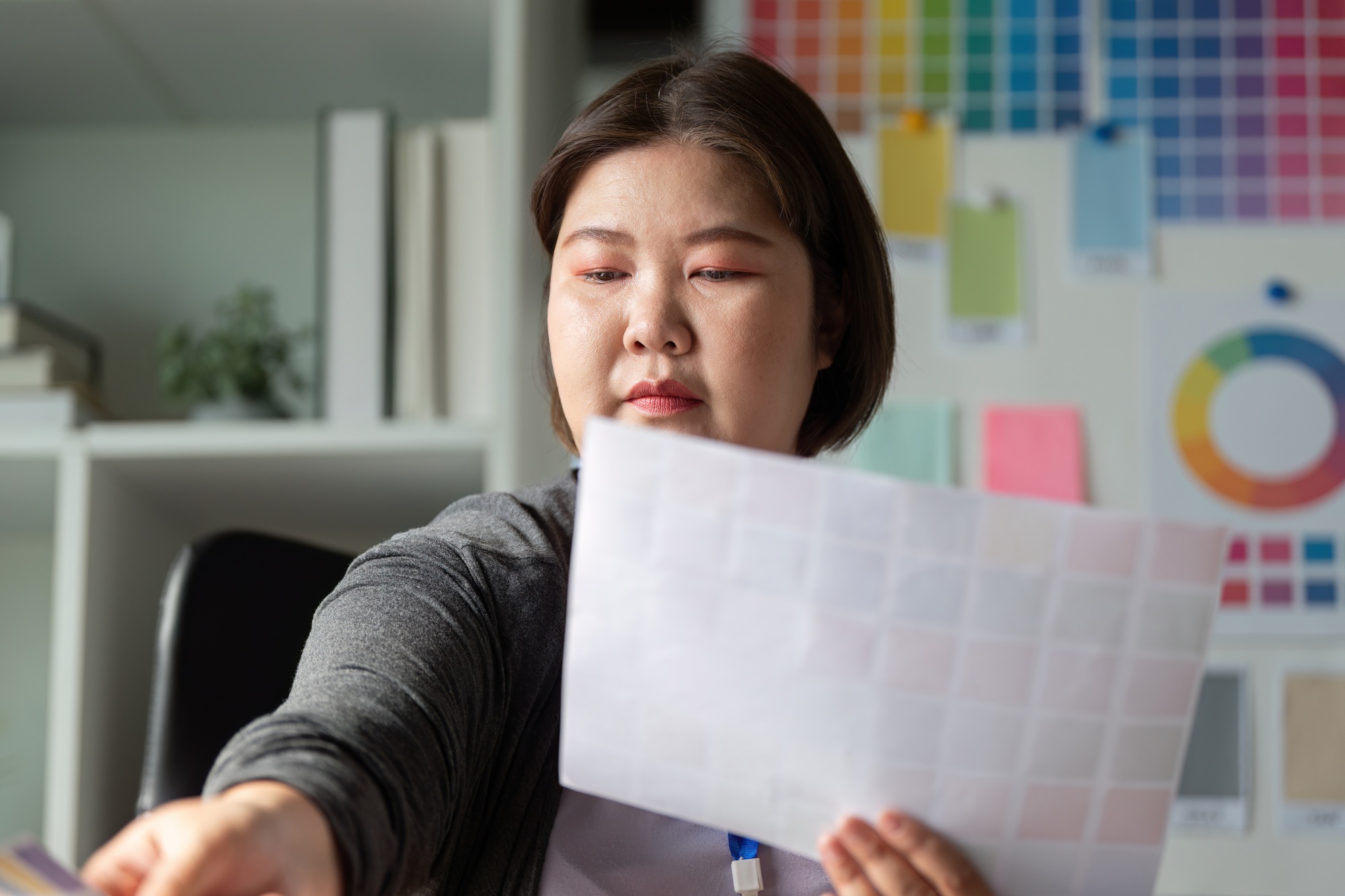 Diverse graphic designer selecting color swatches for a project in a workspace.