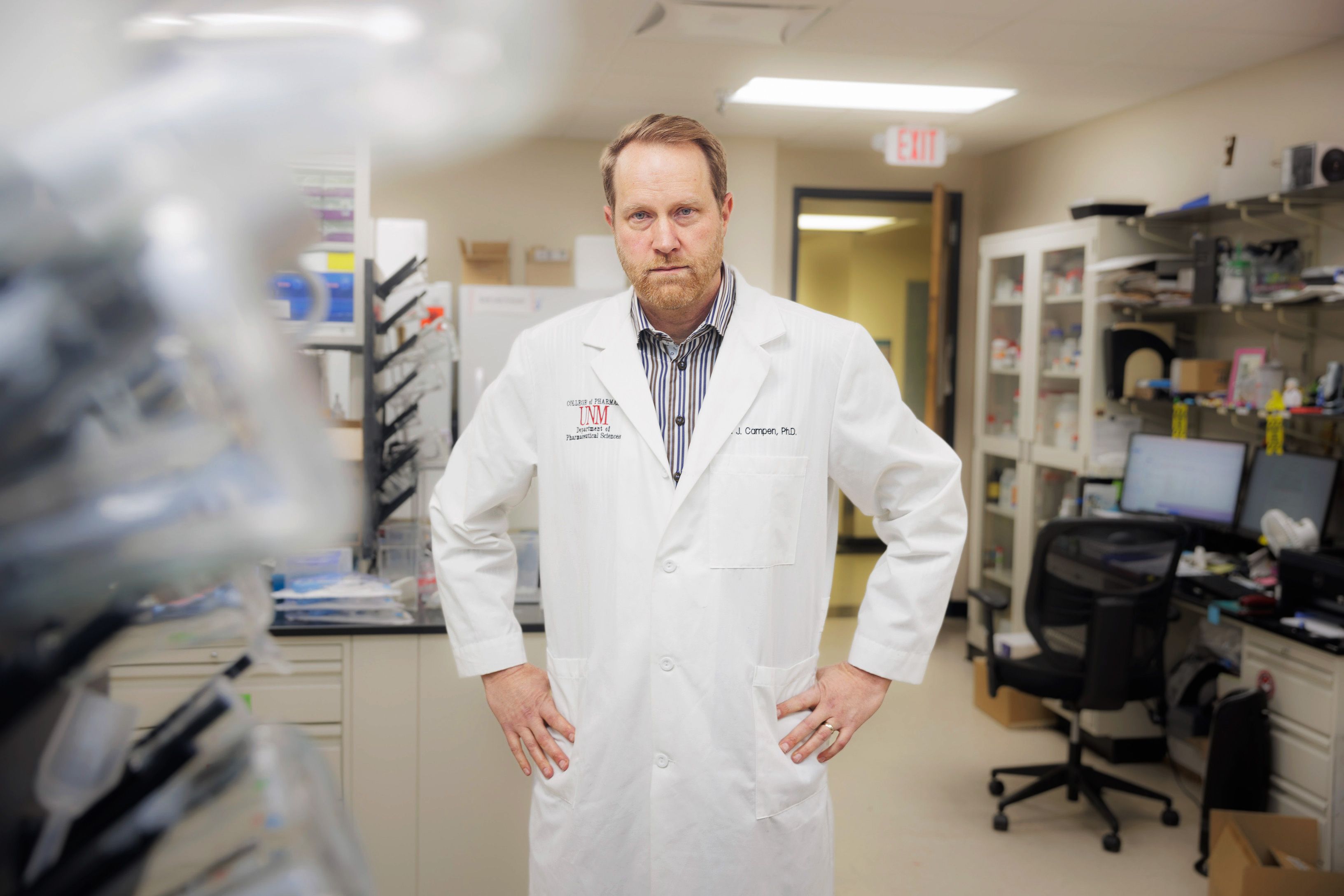 a professional in a lab coat stands in a laboratory setting
