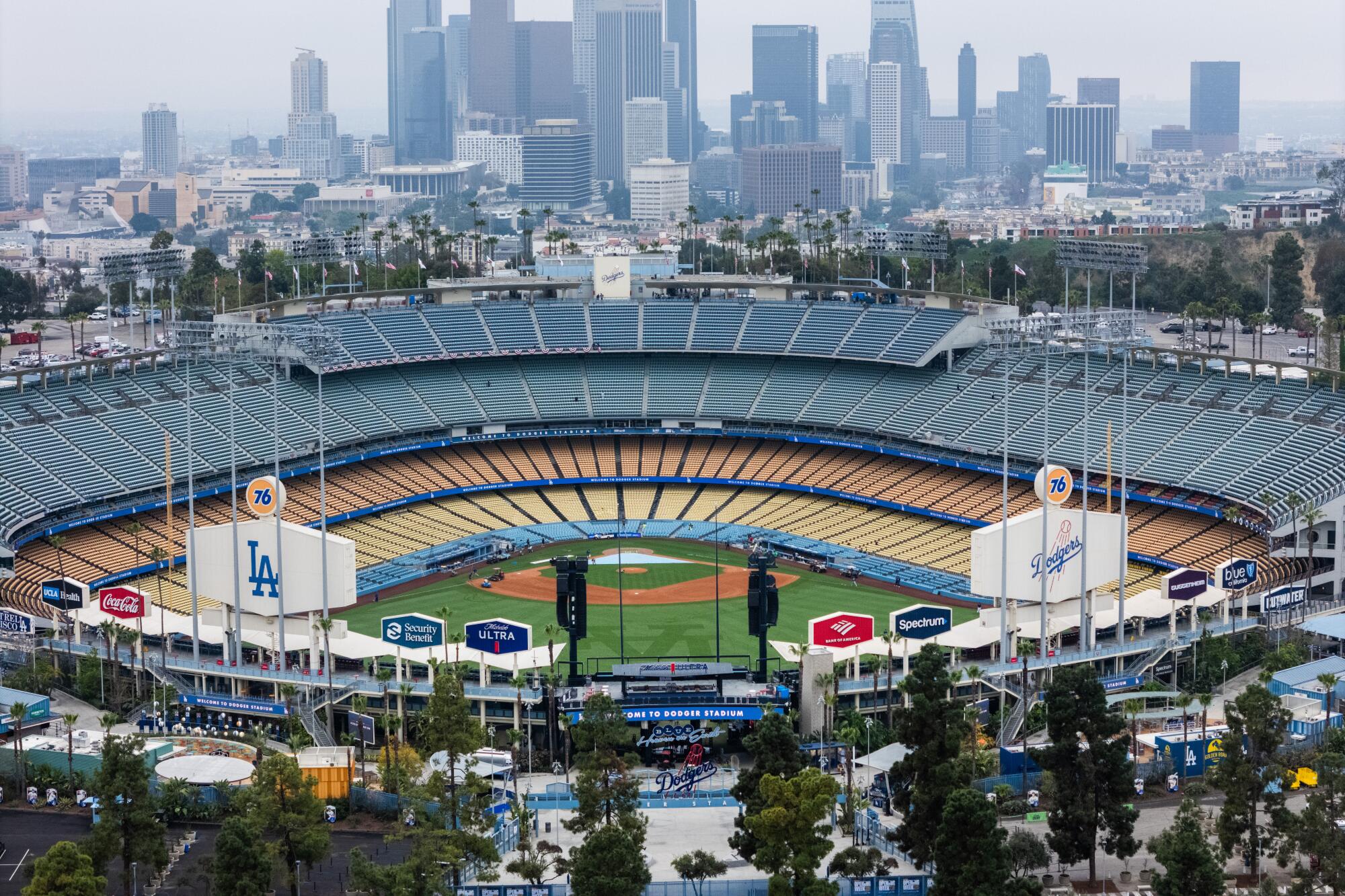 An aerial view of Dodger Stadium with the downtown L.A. skyline behind it.