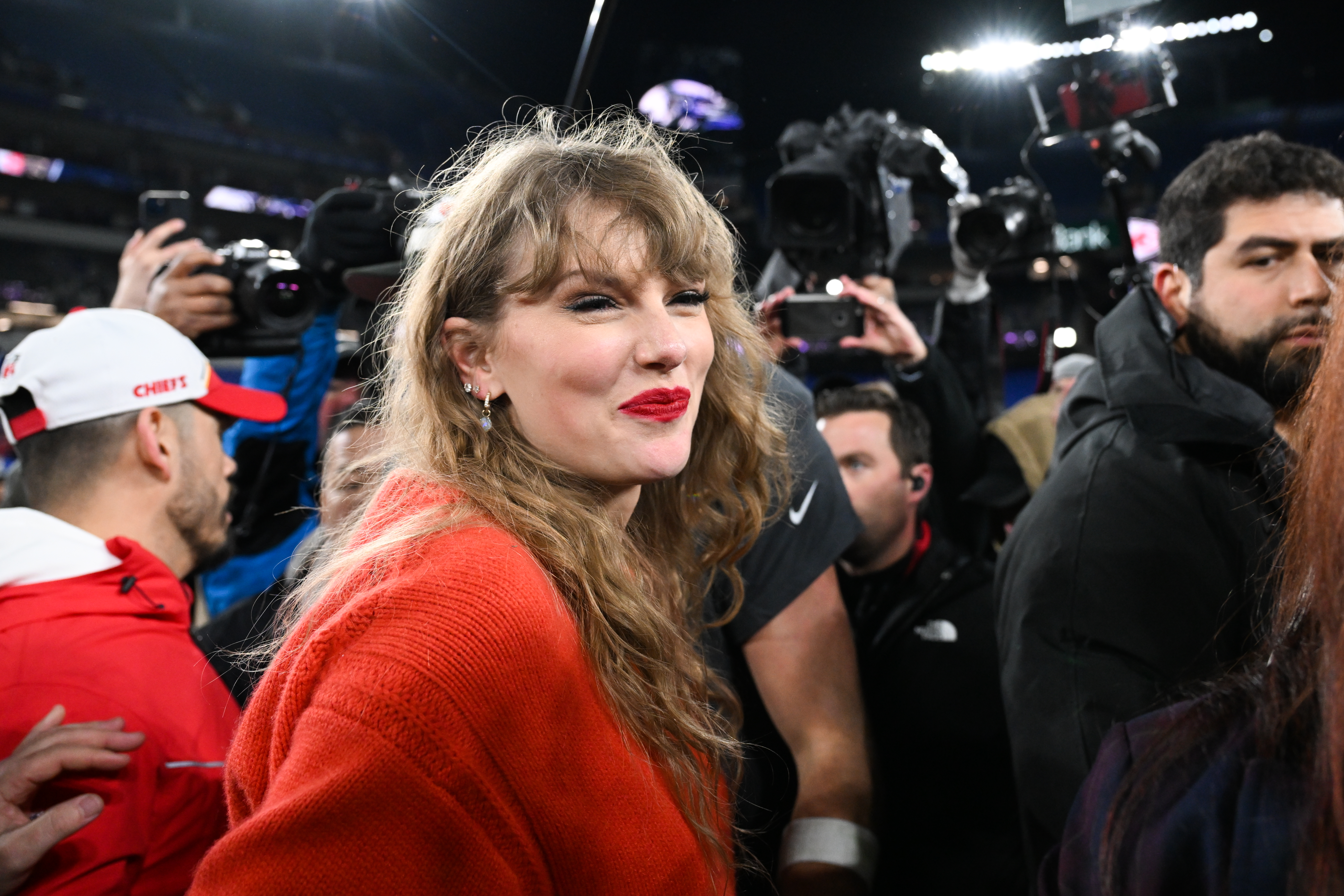 Taylor Swift smiling as she walks off the field after the AFC Championship game.